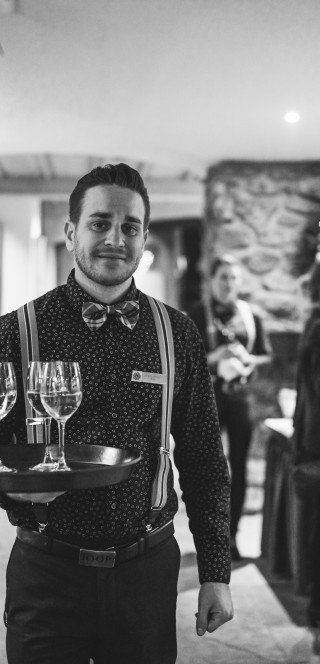 Historic picture of a waiter in 110 Years Posthotel